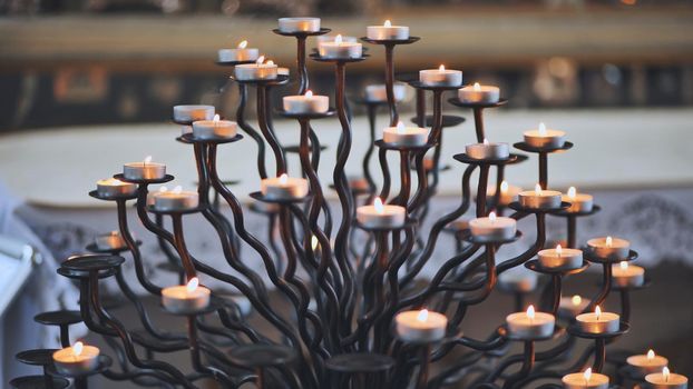 Candlestick holder with burning candles in a Catholic church.