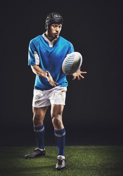 Hes a fierce competitor. Full length studio shot of a young rugby player on the field.