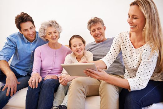 Happy times together. a happy multi generation family using a tablet together.
