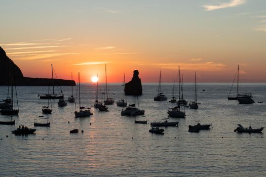 Summer sunset in Cala Benirras with anchored boats