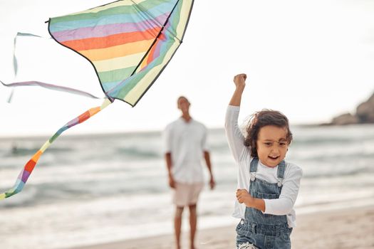 Family, beach and kite with child running for summer holiday, happiness and childhood while father watches. Happy, youth and childhood with young girl playing with colorful toy at seaside vacation