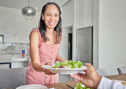 Wife, healthy food and salad while serving lunch or supper for husband with a smile at home. Caring and happy housewife woman with a dinner plate and enjoying a vegan meal at the table together