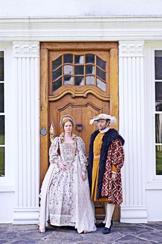 Our humble abode is yours. a royal couple standing in front of their home.