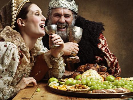 Mead and merriment. A mature king feasting alone in a banquet hall.