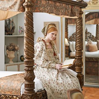 Elegance of the high born. Portrait of an elegant noble woman reading in her palace room.