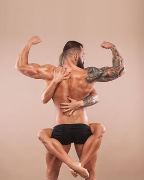 Muscular young fitness sports man and woman with strong fit body on light background.