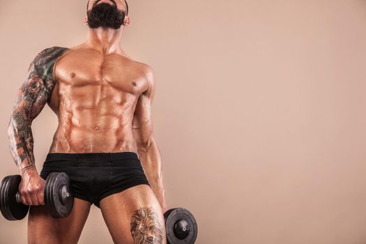 Muscular young fitness sports man with strong fit body on light background.