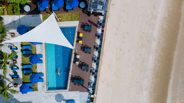 Aerial view from above at pool, tropical swimming pool from above with drone