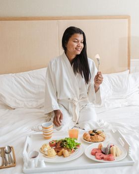 couple having breakfast in bed, men and women in bedroom having breakfast in the morning