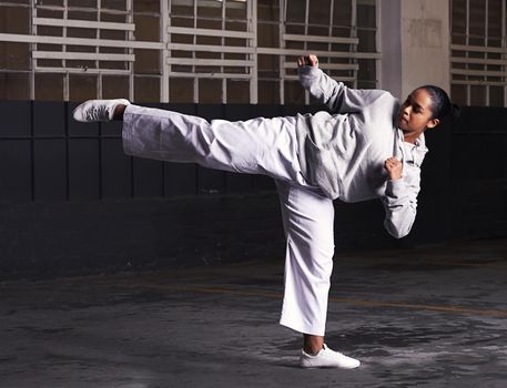 Balance and speed is key in martial arts. a young woman practicing martial arts.