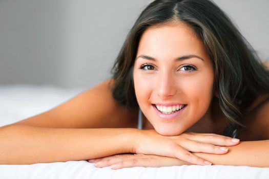 I need nothing else but my smile. a beautiful young woman relaxing on her bed.
