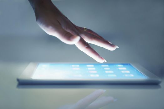 Intuitive technology. Cropped closeup of a womans hand above a digital tablet.