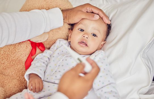 Baby, sick with covid and fever with a thermometer from a parent of an unwell kid in bed of the bedroom of their home. Hand, forehead and healthcare with a child feeling unwell and resting in a house