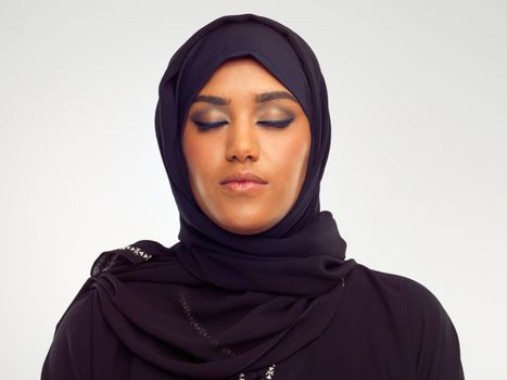 Her beauty is the connection she has with her religion. Studio shot of a young muslim woman with her eyes closed.