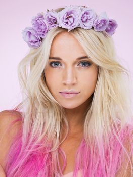 The queen of pinks and purples. Studio shot of a beautiful young woman wearing a flower crown.