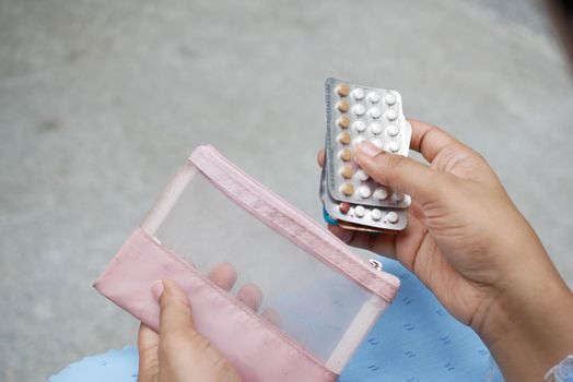 women hand holding birth control pills close up