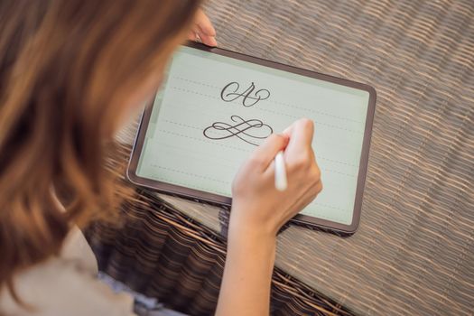 Calligrapher Young Woman writes phrase on digital tablet. Inscribing ornamental decorated letters. Calligraphy, graphic design, lettering, handwriting, creation