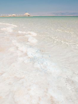 Landscape view on Dead Sea salt crystals formations, clear cyan green water at Ein Bokek beach, Israel