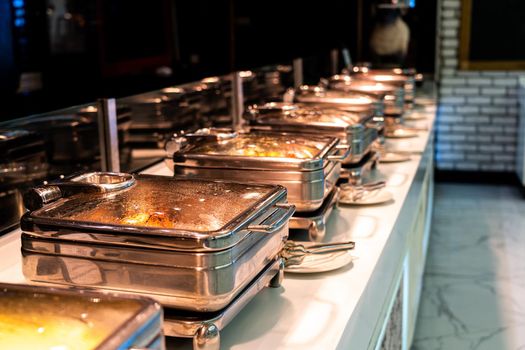 Many buffet heated trays ready for service in hotel restaurant