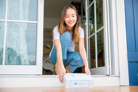 Close up hands of sick Asian woman sitting at door to receive medication first aid pharmacy box 