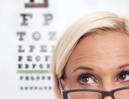 Sight for sore eyes. A cropped shot of a beautiful optometrist in front of a snellen chart.