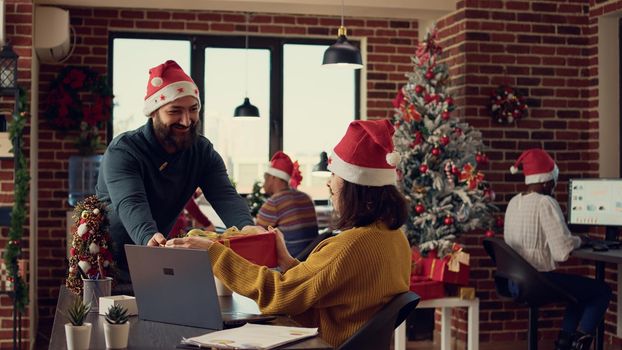 Office employees exchanging presents at work