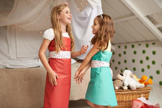 I like that dress youre wearing. two little girls having fun dressing up.