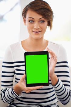 You have got to see this. Portrait of a surprised young woman showing her tablet.