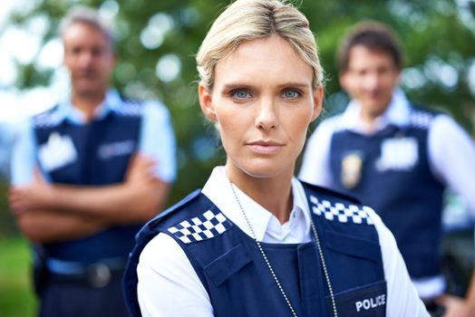 Shes on your case. a serious policewoman with her colleagues in the background.