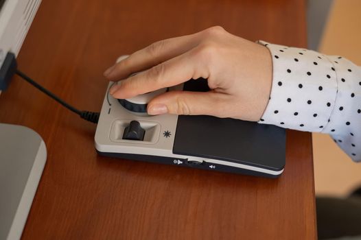 A woman uses a special magnification device for the visually impaired.