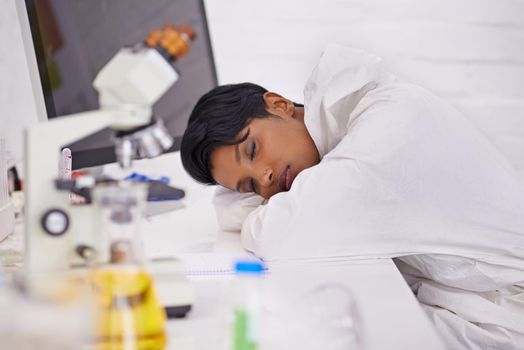 Shes a hard worker. A beautiful young scientist napping on her desk in her lab.