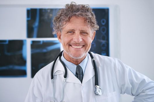 Dedicated to improving your quality of life. Portrait of a smiling mature radiologist standing in his office.