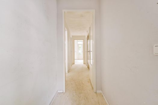 Narrow corridor with doors and lamp