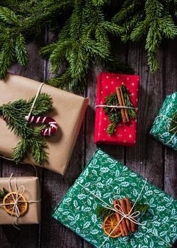 Christmas gift wrapping photo on wooden background. New year boxes with kraft paper decoration from above