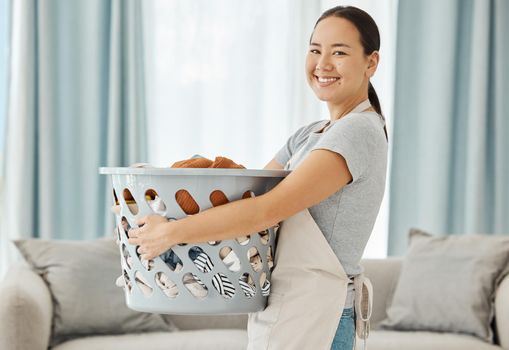 Happy Asian cleaner woman with laundry working for home, house or hotel hospitality cleaning help service agency. Japanese girl maid or worker smile in apartment with dirty clothes in washing basket