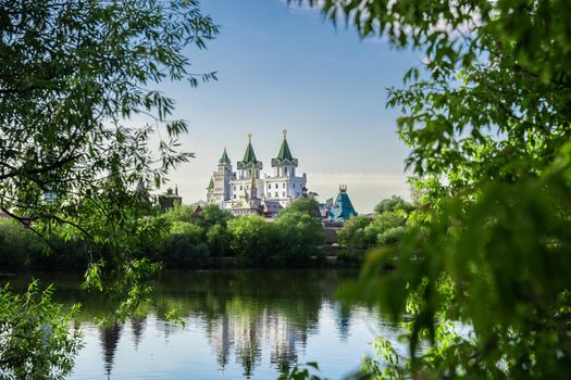 Moscow, Russia 2022. Izmailovo Kremlin on the lake shore in summer framed by tree branches,