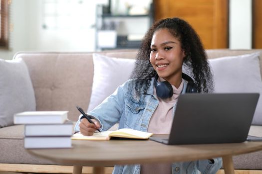 Portrait of happy female student with dark skin smiling at camera. cheerful African American hipster girl enjoying e learning and preparation to course work