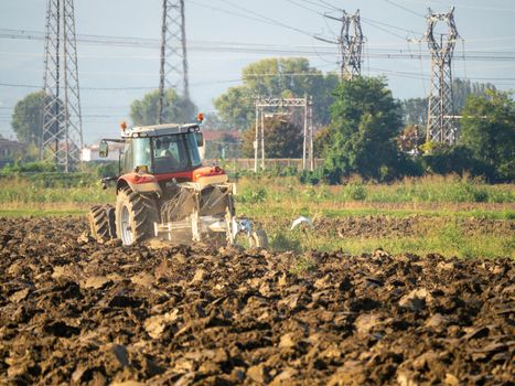 Farmer driving tractor plowing land at the end of the summer season