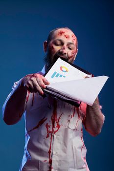 Creepy zombie looking at business documents