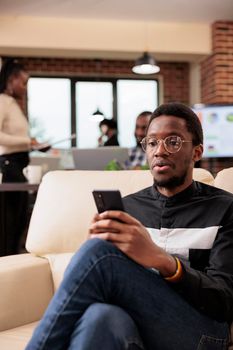 Startup employee browsing internet on smartphone