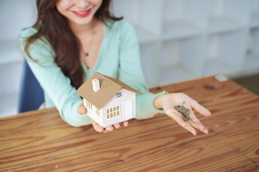 The customer holds the house model and keys