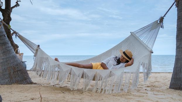 women sleeping in hammock on a beach in Thailand, Asian women taking a nap in afternoon