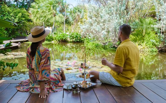 Afternoon tea at a water pond, high tea in tropical garden in Thailand