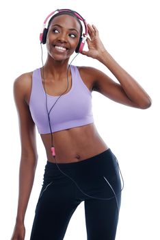 This ones her favourite. A happy young woman in sportswear listening to music with her headphones.