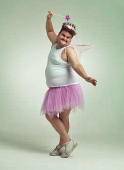 Using my magic wand. An overweight man comically dressed-up in a pink fairy costume.