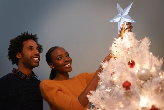 Christmas is a time of hope. a loving young couple decorating their Christmas tree.