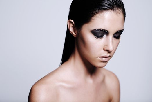 Made up in minerals. Studio shot of a beautiful young woman wearing metallic-colored makeup.