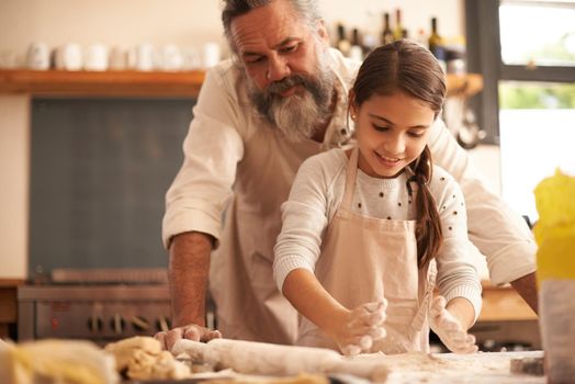 Pure kitchen delight. a girl bonding with her grandfather as they bake in the kitchen.