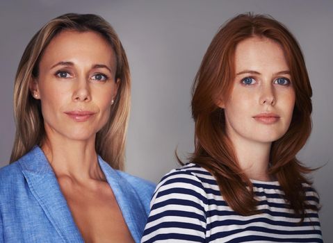 Theyre a dynamic mother-daughter duo. Cropped portrait of two attractive women standing in the studio.