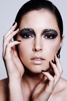 Metallic magic makeup. Portrait of a beautiful young woman wearing metallic-colored makeup and nail polish.